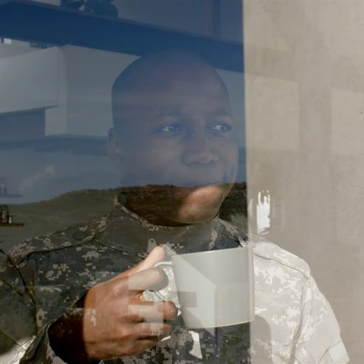 A_man_sips_coffee_while_gazing_through_a_reflective_window_ours