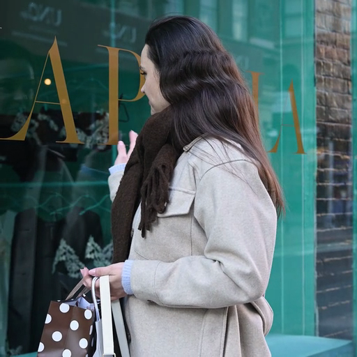 A_woman_shopping_and_admiring_a_window_display_at_a_boutique_store_ours